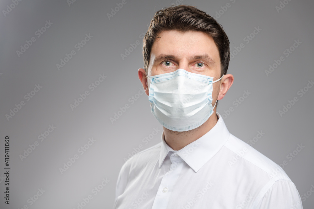 Man in a protective face mask, an office worker in white shirt wearing a mask to protect against covid-19. Businessman portrait on pandemic time. Man in a protective face mask, an office worker in white shirt wearing a mask to protect against covid-19. Businessman portrait on pandemic time.