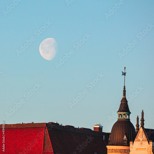 Moon in the sky, Dawn, Spring panorama of Helsinki, view on
  rooftops of Krununhakka buildings photo