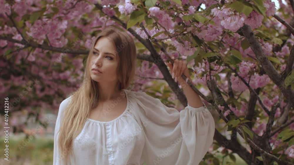 Spring Beauty Portrait of a Woman at Blossoming Sakura Tree on Nature Spring Beauty Portrait of a Woman at Blossoming Sakura Tree on Nature