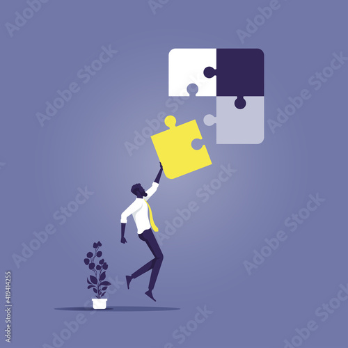 Businessman connecting the last piece of jigsaw puzzle to complete the mission