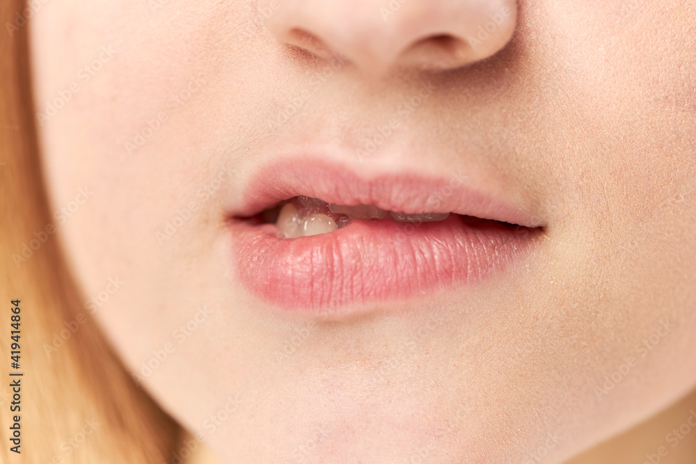 Obraz premium Close-up photo of a woman biting her lips against