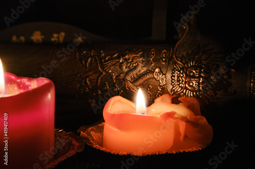 Candlelight illuminates the scabbard of an ancient Chinese sword with dragon