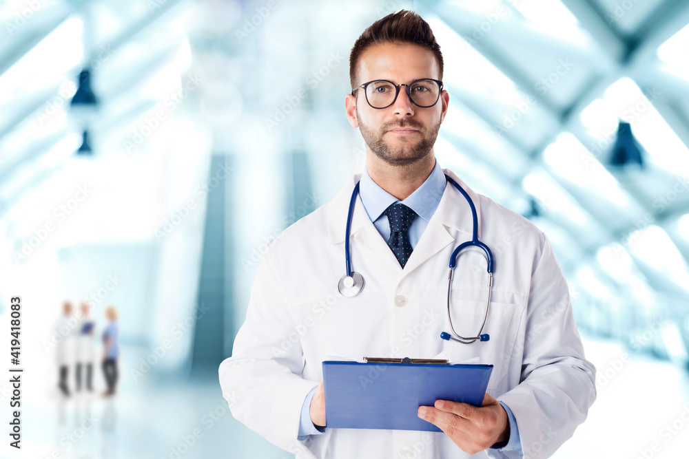 Young doctor portrait while standing in the hospital foyer Young doctor portrait while standing in the hospital foyer