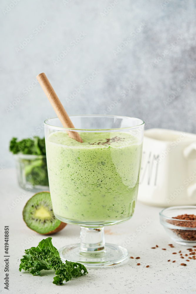 Detox green smoothie with kale, spinach and kiwi on a light gray slate, stone or concrete background. Top view with copy space. Detox green smoothie with kale, spinach and kiwi on a light gray slate, stone or concrete background. Top view with copy space.