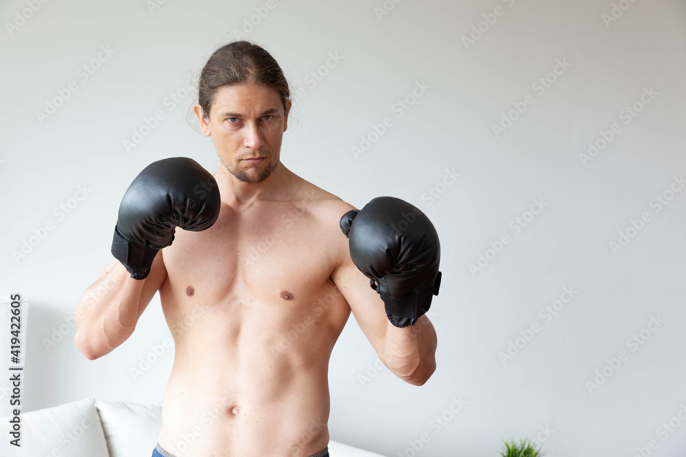 A sport man has boxing training in his living room at home