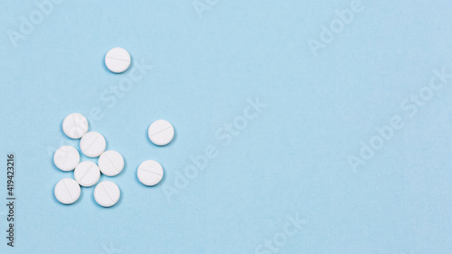 Photos White pills on the blue background, medical banne