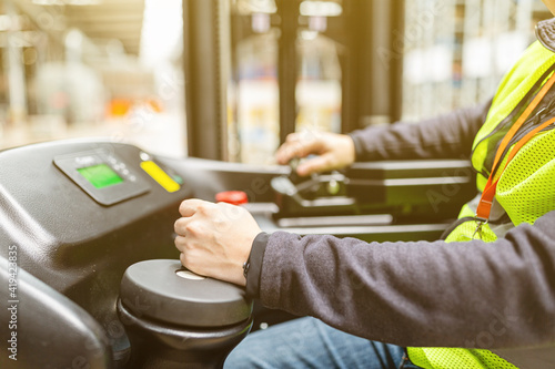 Storehouse employee in uniform working on reachtruck in modern automatic warehouse. Warehousing, machinery concept. Logistics in stock. photo