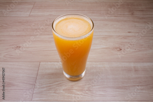 citrus juice in glass decanter with orange on wooden background. Horizontal orientation. Copy space.