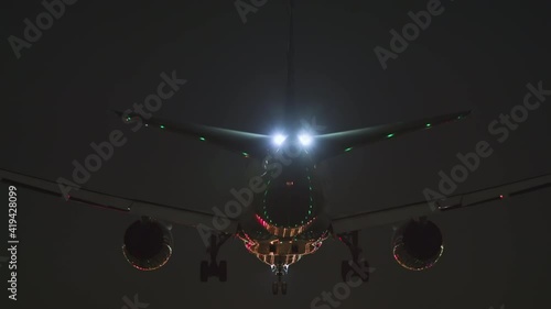 Jet air plane comes in to land. Night time. Transportation, flights and travel concepts. Bad weather, grounded aircraft fleet, covid pandemic. Airlines closing down. Dark ominous feeling