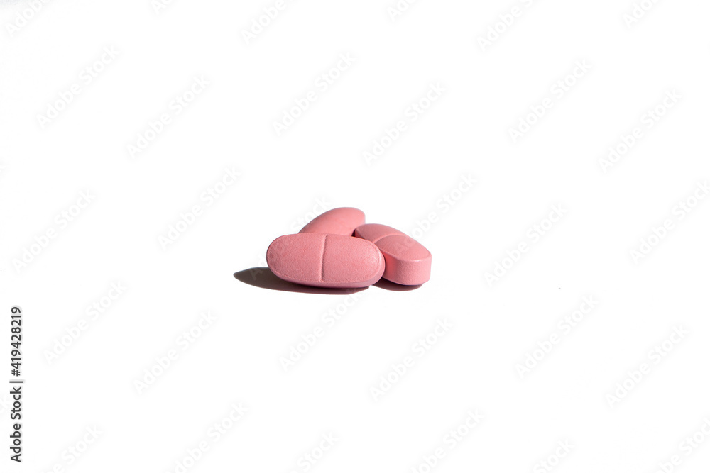 Three Pills of pink color on a white background. Isolated. Hard shadows Three Pills of pink color on a white background. Isolated. Hard shadows