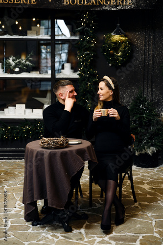 husband with his pregnant wife are sitting at the table pregnant woman drinks tea and communicates with her loved one sitting at the restaurant table. family New Year atmosphere.