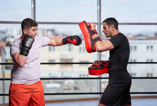 Overweight kickboxer hitting mitts © Xalanx