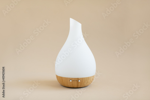White and wood essential oil diffuser on tan background