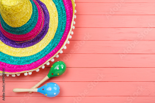Mexican hat and maracas on wooden table