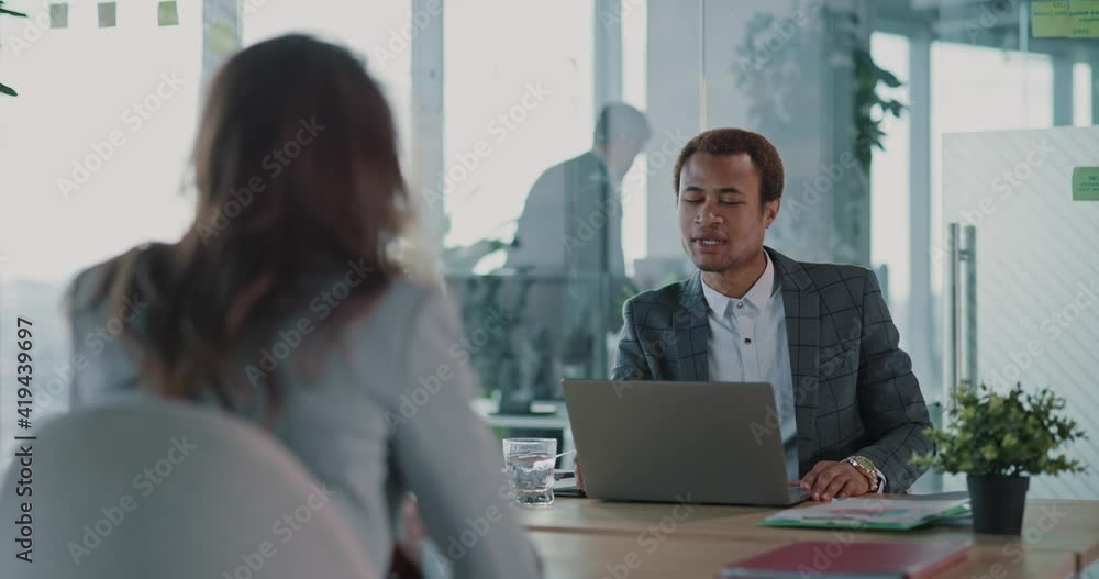 Job Interview. Young Woman Candidate Applying for New Job Talking with African Male Manager Discussing Future Opportunities in Corporate Office. Job Interview. Young Woman Candidate Applying for New Job Talking with African Male Manager Discussing Future Opportunities in Corporate Office.