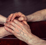 the older man holds the woman's hands