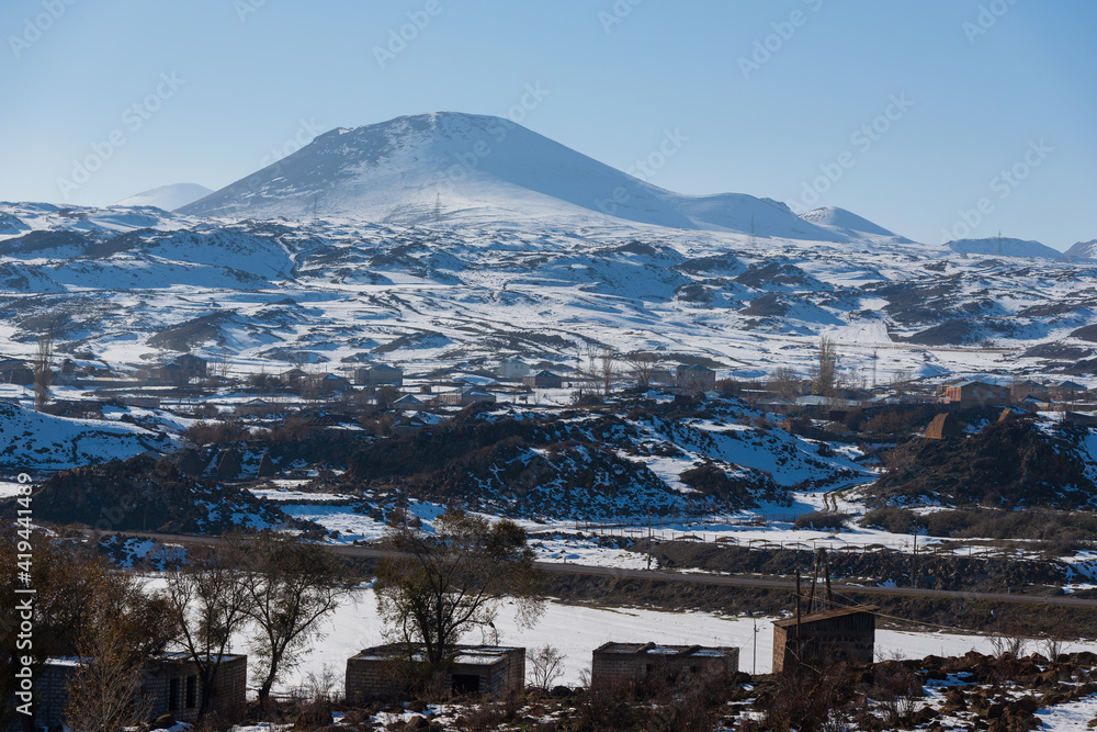 Winter scene with volcanic mountains and village