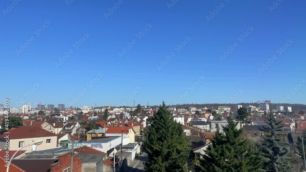 View from the train passing in suburban area with a bright blue sky and small houses in France, sliding shot View from the train passing in suburban area with a bright blue sky and small houses in France, sliding shot
