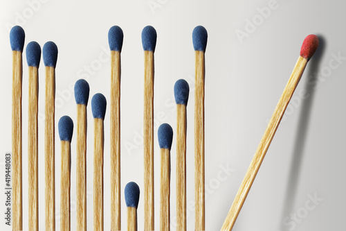 Φωτογραφία Wooden matches are lined up with a dozen blue matches on the left and one red match isolated and alone