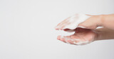 Hands washing gesture with foaming hand soap on white background.