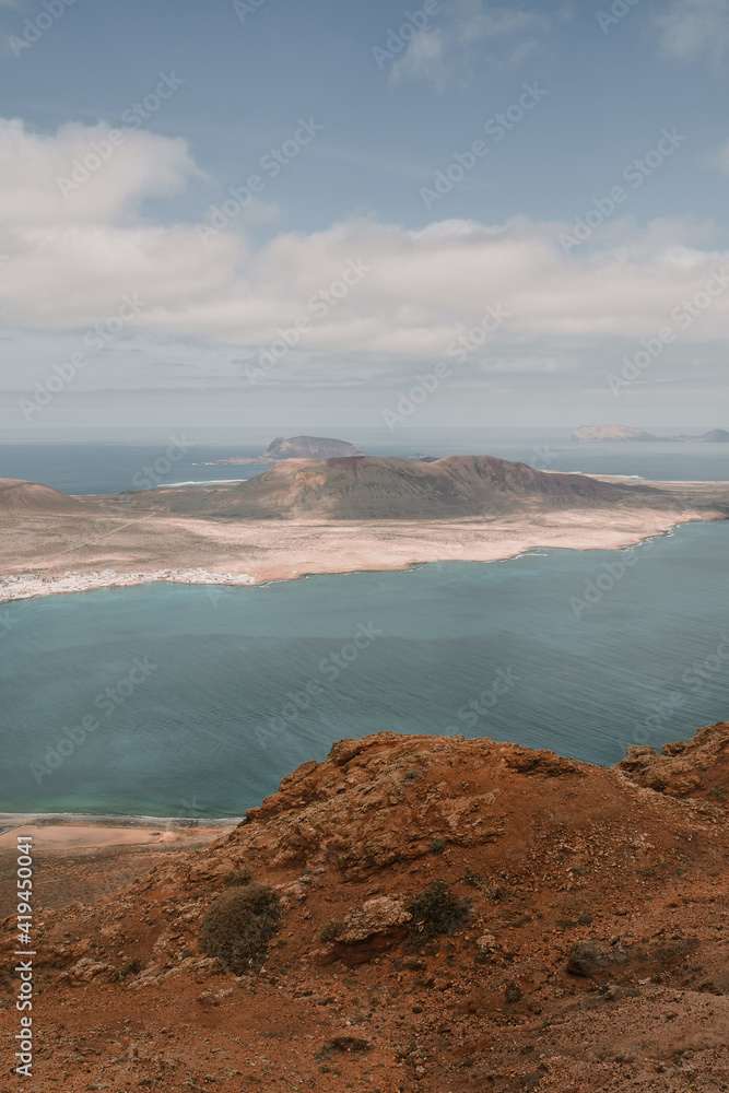 Spectacular view of island in calm rippling sea under blue sky on Lanzarote Spectacular view of island in calm rippling sea under blue sky on Lanzarote