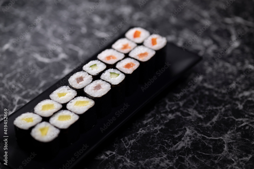 set of sushi rolls with seafood on a black stone background set of sushi rolls with seafood on a black stone background