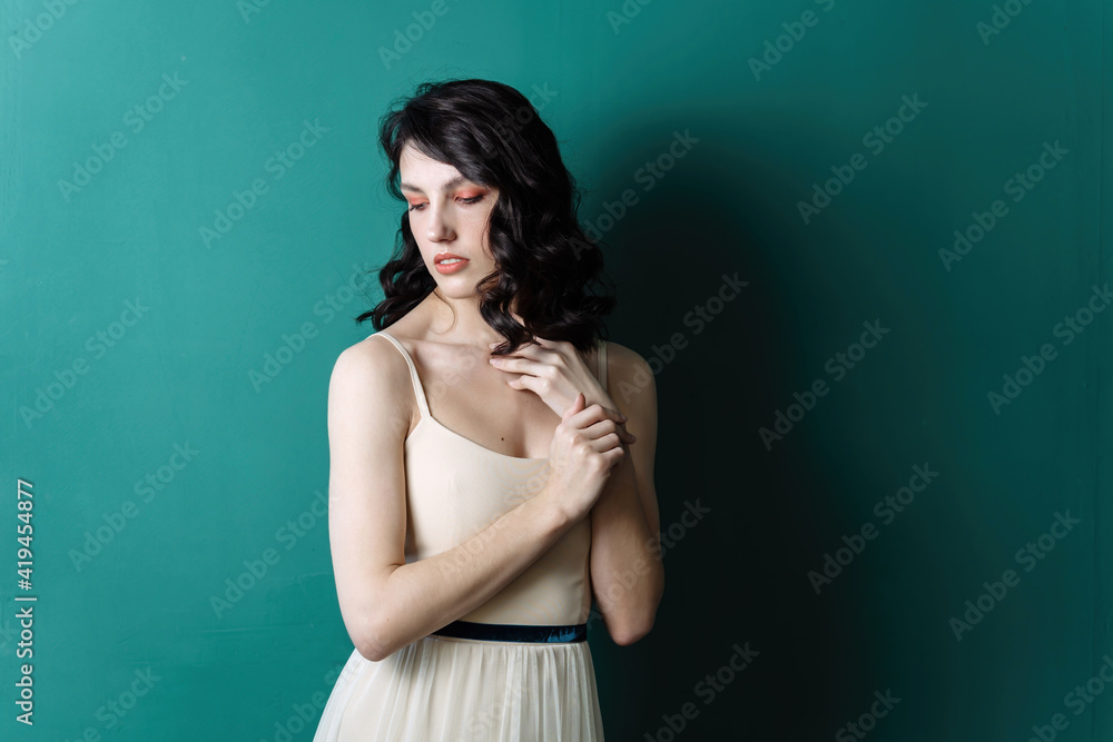 Elegant lady portrait. Pearls jewelry set posing isolated on studio green background. Sensual look downward Elegant lady portrait. Pearls jewelry set posing isolated on studio green background. Sensual look downward