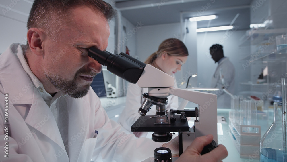 Diverse scientists studying medical samples. Using computers and microscopes. Modern laboratory interior Diverse scientists studying medical samples. Using computers and microscopes. Modern laboratory interior