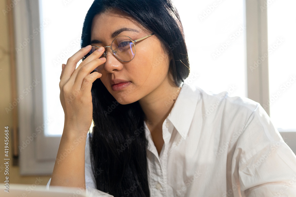 Crop thoughtful ethnic female self employed freelancer in eyeglasses working on gadget at home Crop thoughtful ethnic female self employed freelancer in eyeglasses working on gadget at home