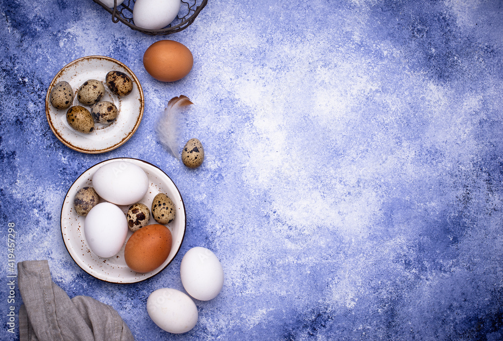 Quail and chicken eggs on blue background Quail and chicken eggs on blue background