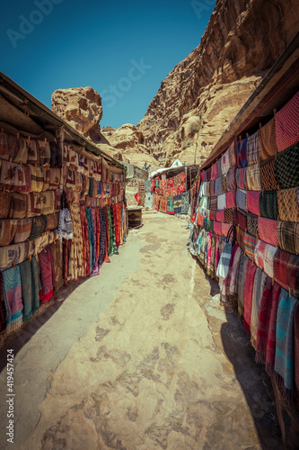 Shopping street with market in the ancient city of Petra in Jordan with souvenir products, fabrics and carpets with national Bedouin ornaments © Lana Kray