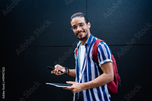 Fényképezés Half length length portrait of cheerful african american guy using modern gadget