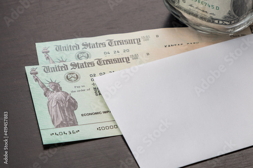 US economic stimulus checks with dollar bills in the background