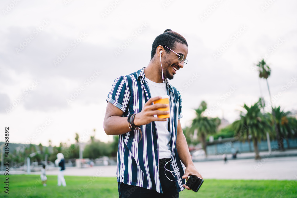 Obraz premium Happy young ethnic man standing in park