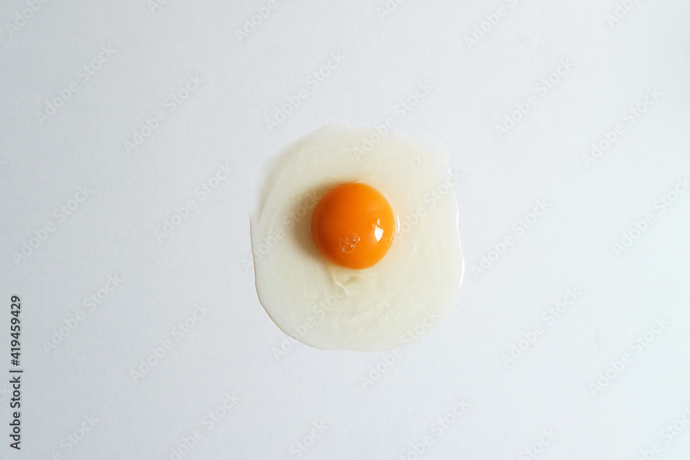 Top view of fresh raw chicken egg placed on white background in bright studio Top view of fresh raw chicken egg placed on white background in bright studio