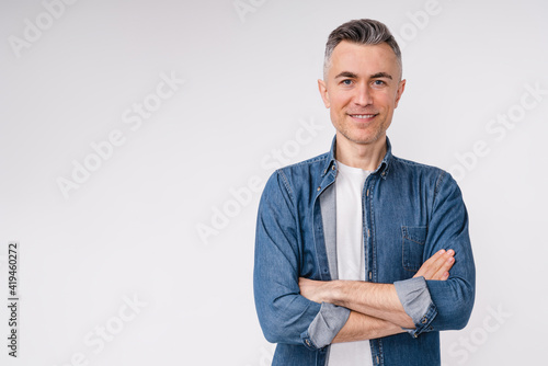 Confident caucasian middle-aged man in casual clothes with his arms crossed isolated over white background photo