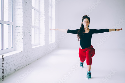 Fototapeta Naklejka Na Ścianę i Meble -  Caucasian sportswoman in active wear training in gym stretching muscles during workout pilates, young athletic girl exercising in studio keeping fit and healthy lifestyle and physical concentration