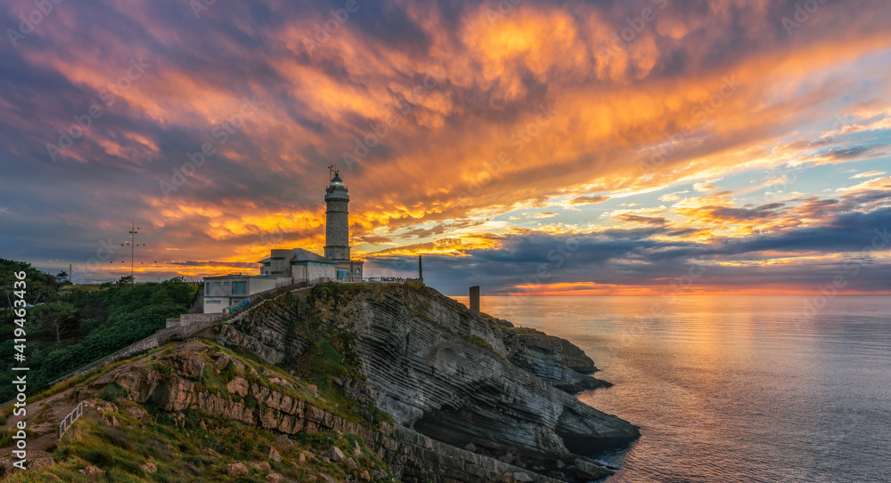 Scenic view of small island with lighthouse called Faro de Cabo Mayor connected with coastline by bridge under dramatic cloudy sky at sunset time in Santander in Spain Scenic view of small island with lighthouse called Faro de Cabo Mayor connected with coastline by bridge under dramatic cloudy sky at sunset time in Santander in Spain