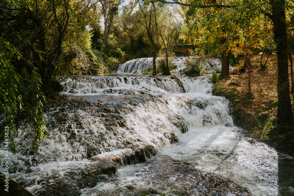 Wonderful scenery of stream of cascade waterfall surrounded by trees in autumn forest Wonderful scenery of stream of cascade waterfall surrounded by trees in autumn forest
