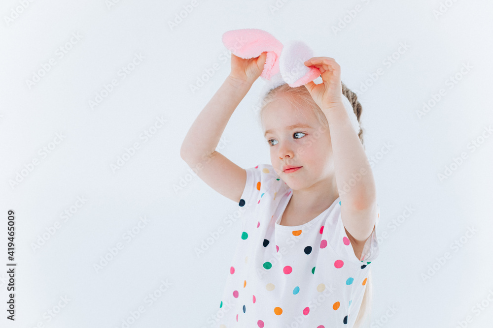 Funny curly girl plays with bunny ears on isolated background. Easter holiday concept Funny curly girl plays with bunny ears on isolated background. Easter holiday concept