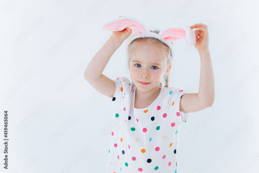 Funny curly girl plays with bunny ears on isolated background. Easter holiday concept Funny curly girl plays with bunny ears on isolated background. Easter holiday concept