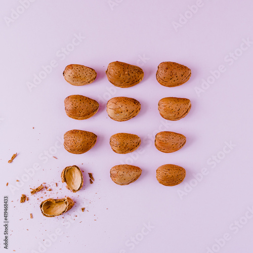 Top view of whole crispy oval shaped nuts near halves of shell representing uniqueness and chaotic concepts