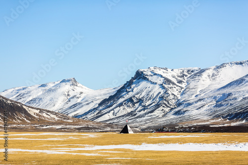 Spectacular landscape of wigwam located in valley in highlands covered with snow on sunny day in winter in Iceland photo