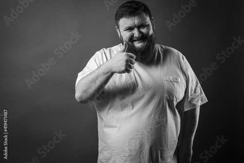  portrait of a bearded cheerful, emotional and interesting man in a white T-shirt on a blue background showing various hand gestures. Cheerful guy is a show business artist, host of a glamorous show. 