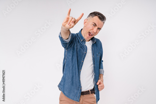 Excited caucasian middle-aged man showing rock-n-roll gesture isolated over white background
