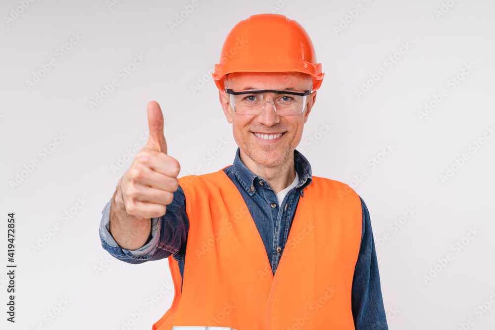Confident caucasian male engineer in hardhat and uniform showing thumb up isolated over white background Confident caucasian male engineer in hardhat and uniform showing thumb up isolated over white background