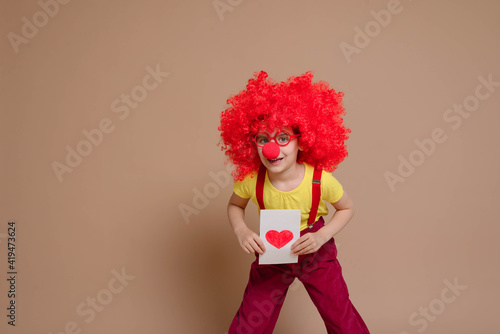 April 1 concept of April fool's Day. Happy Valentine's Day. Bright red Cupid on Valentine's day. Let's celebrate. Funny baby clown playing at home. Selective focus.