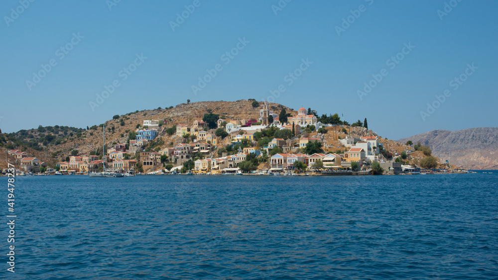 Beautiful view from the water of colorful Symi island in summer. Dodecanese, Greece