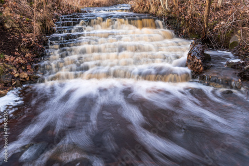 waterfall in several stages and fallen leaves