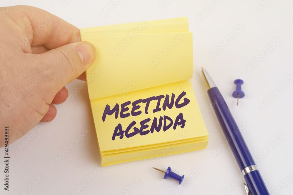 The man is leafing through the stickers, the sheet says - MEETING AGENDA The man is leafing through the stickers, the sheet says - MEETING AGENDA
